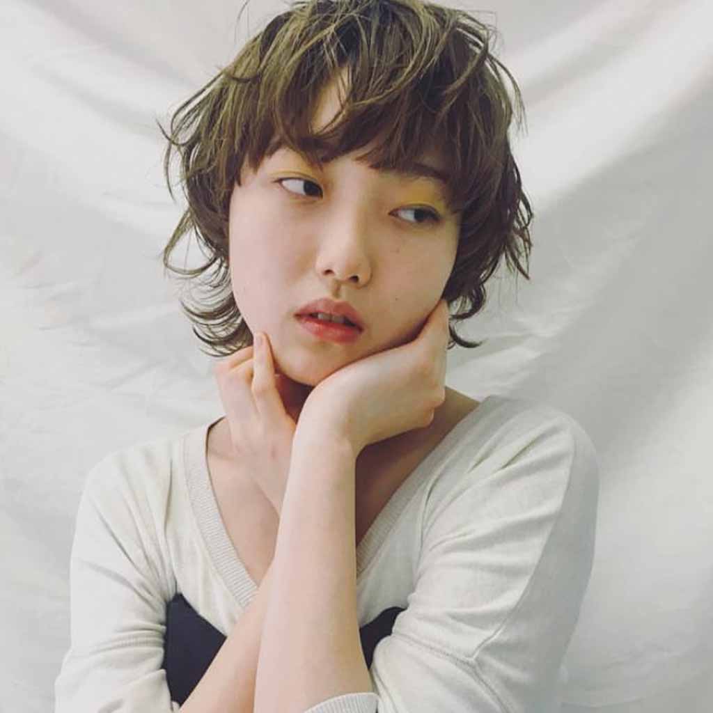 a girl with a shaggy tousled bob wolf cut