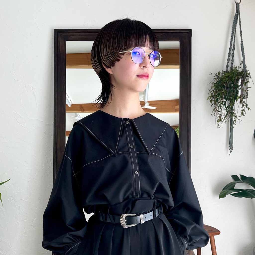 a girl with a mash style bob cut wearing glasses