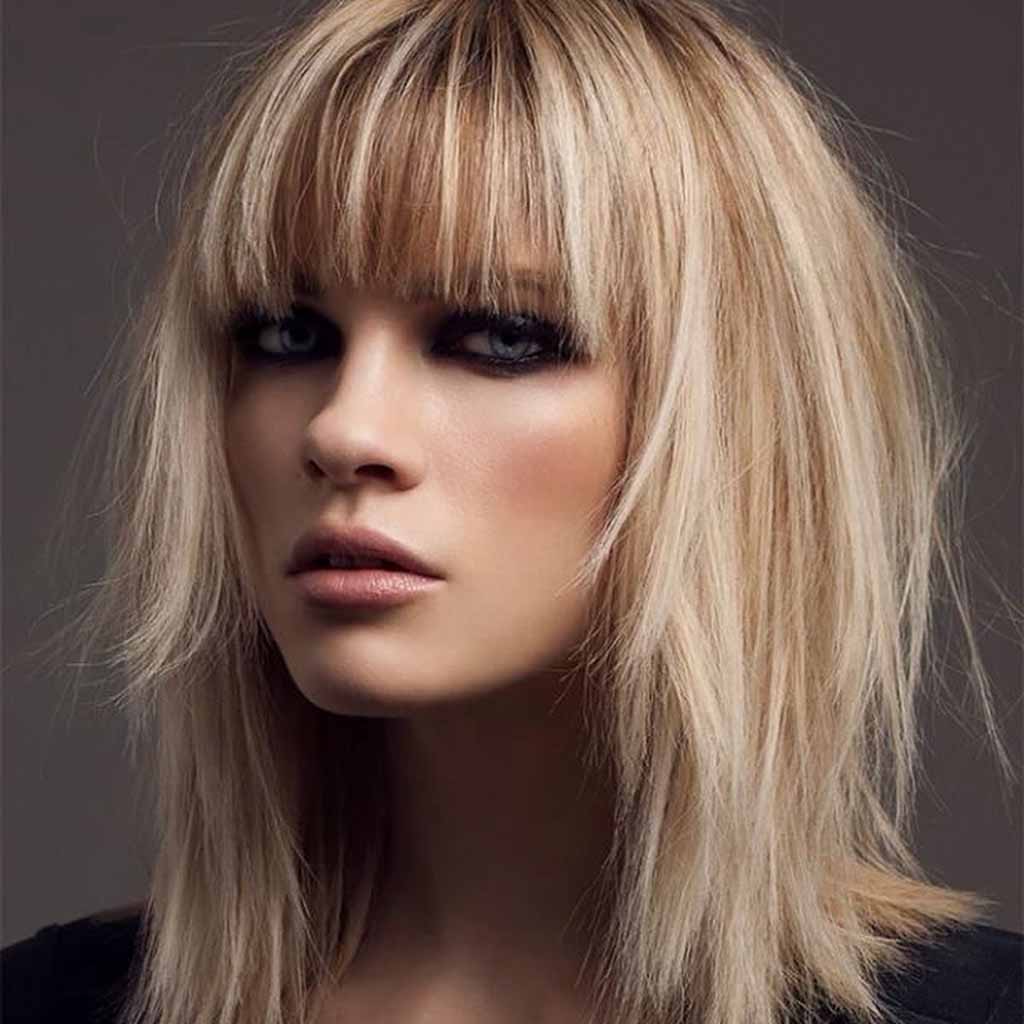 a girl with a blonde bob wolf cut with blue eyes