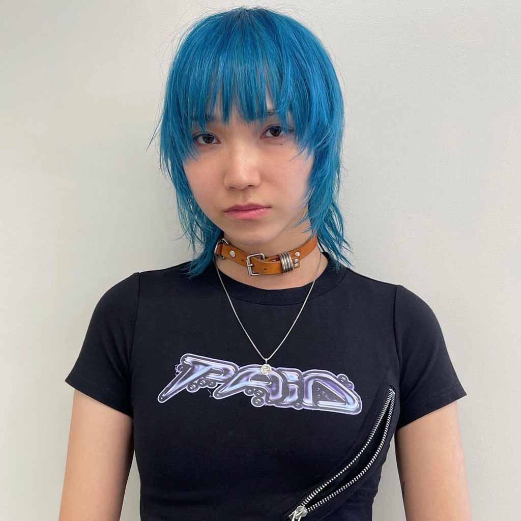 a girl with a blue bob cut, wearing a choker and a black tshirt
