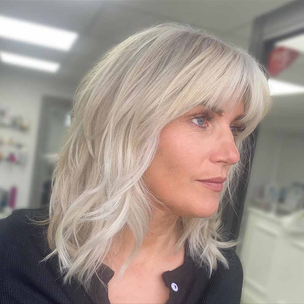 a girl with bleached blonde bob cut with green eyes