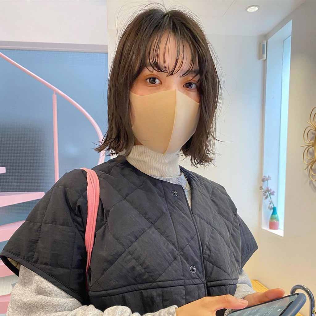a girl with a wolf cut with wispy bangs, wearing a mask and a jacket
