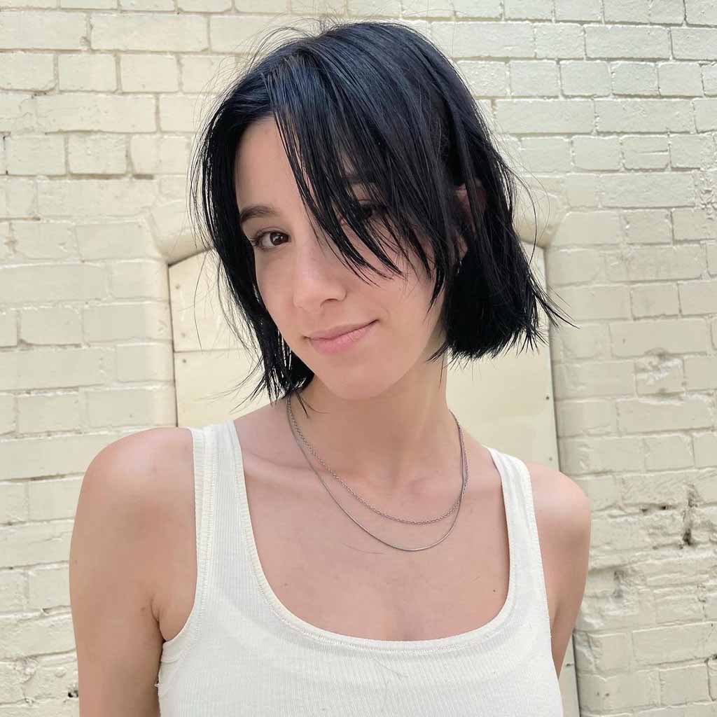 a girl with a bob wolf cut and a white tank top
