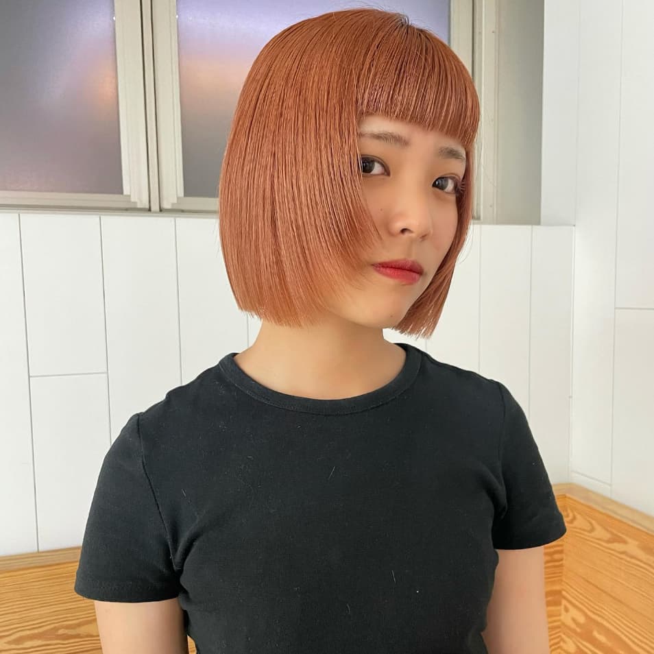 a girl with ginger bob wolf cut wearing a black tshirt